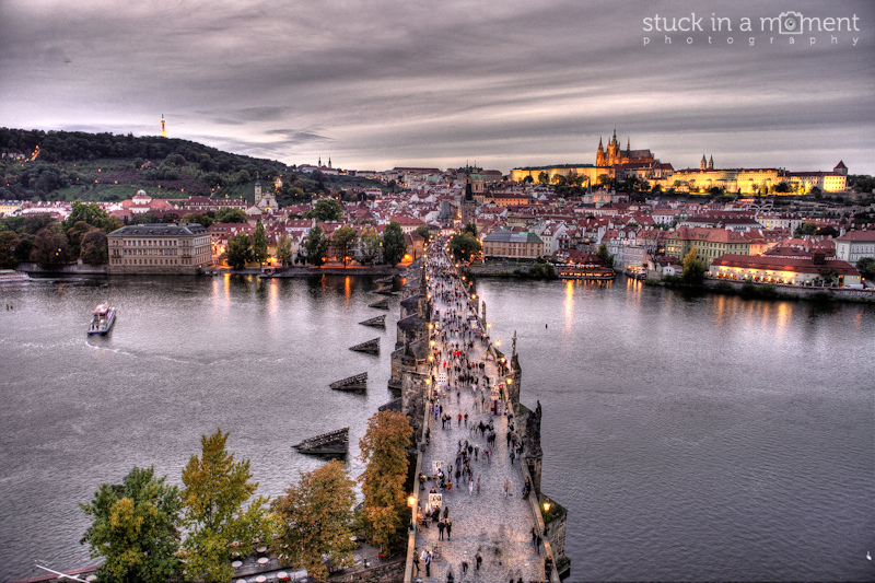 View of Charles bridge from atop Charles tower and the Praha castle in the far right gloriously illuminated